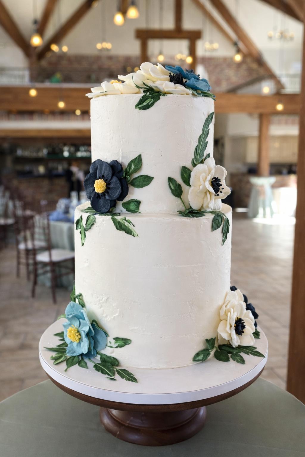Two-tiered cake with blue and white sugar flowers