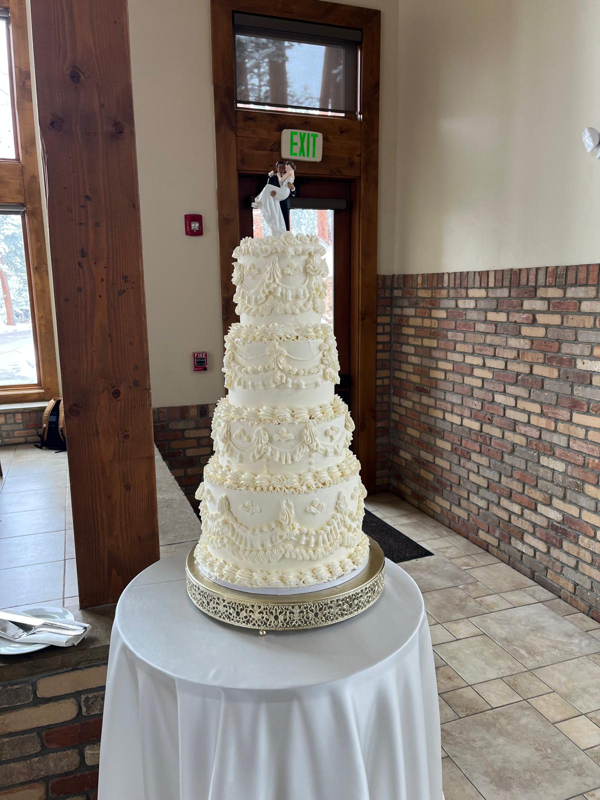 Five-tiered vintage piped cake with bride and groom topper